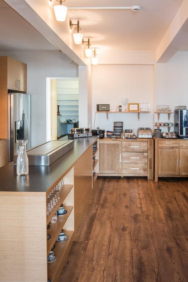 Long breakfast counter with wooden cupboards and a wooden floor