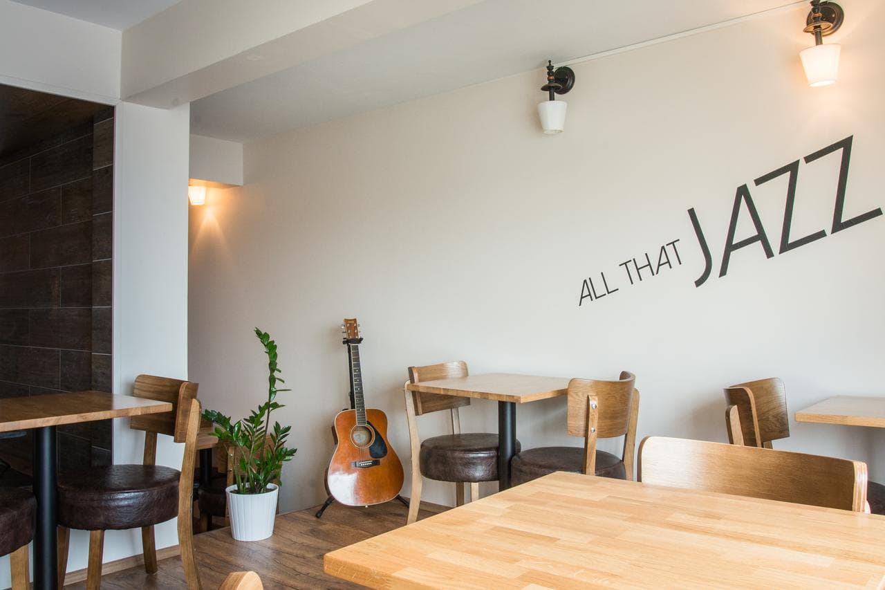Breakfast room with wooden tables, a guitar and the words All that Jazz on the wall