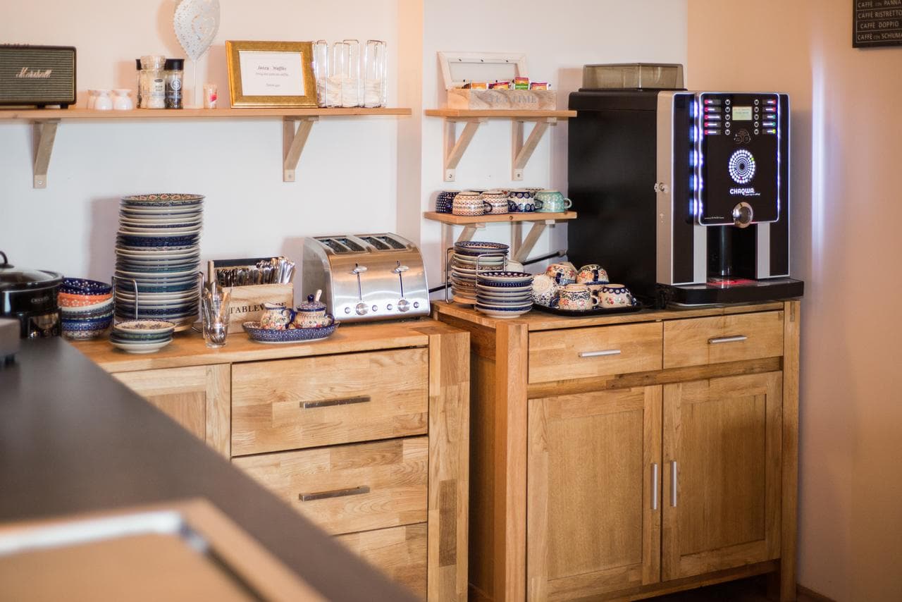 Coffee machine, toaster and plates on wooden breakfast shelves