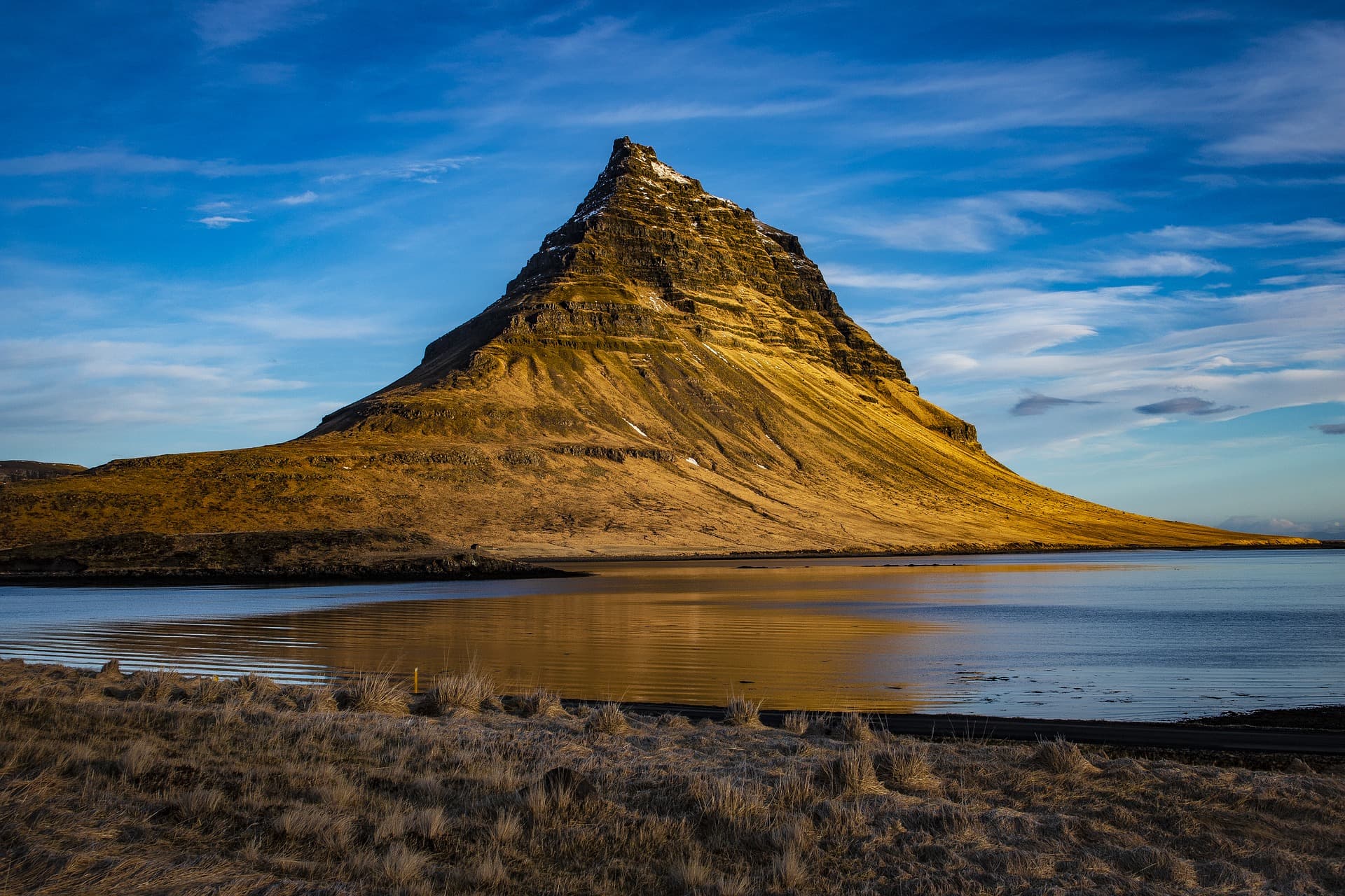 Kirkjufell mountain in golden evening light above the water